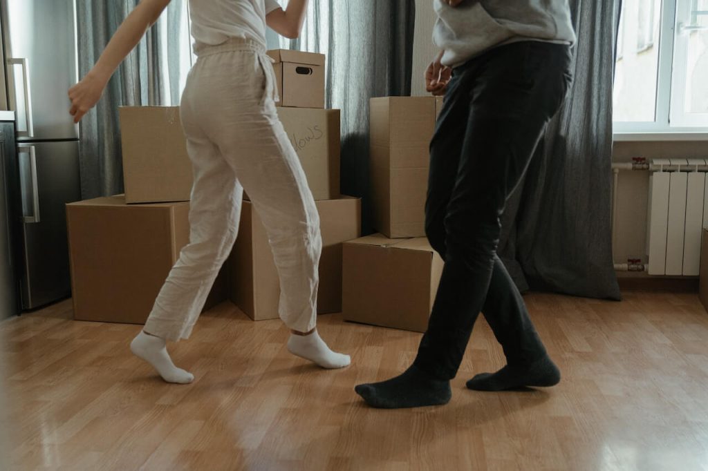 people dancing in the middle of moxing boxes in new home