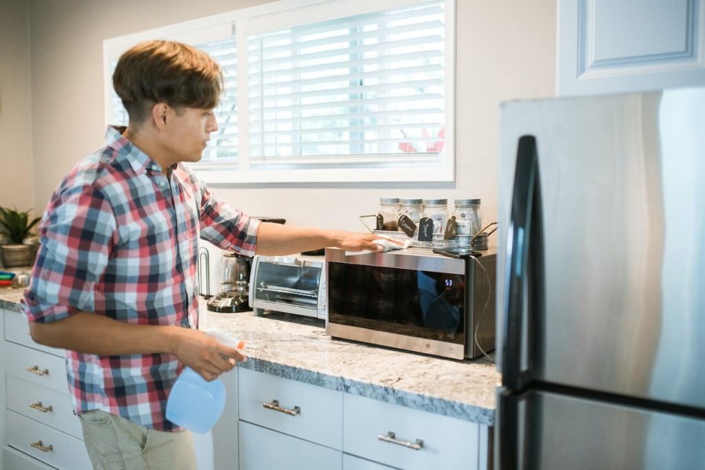 man wiping oven