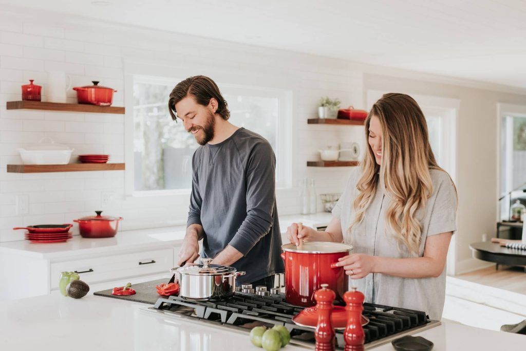 happy couple cooking in a clean kitchen